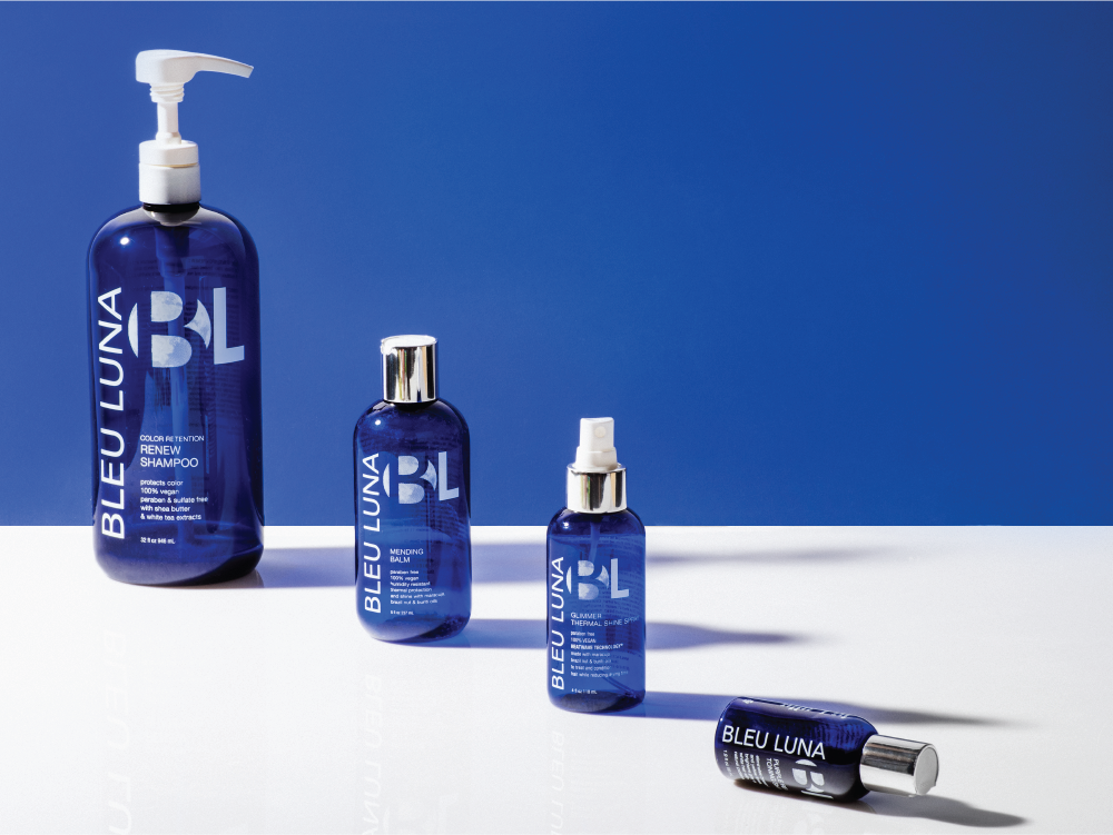 4 blue shampoo bottles with the Bleu Luna logo and labels on them.