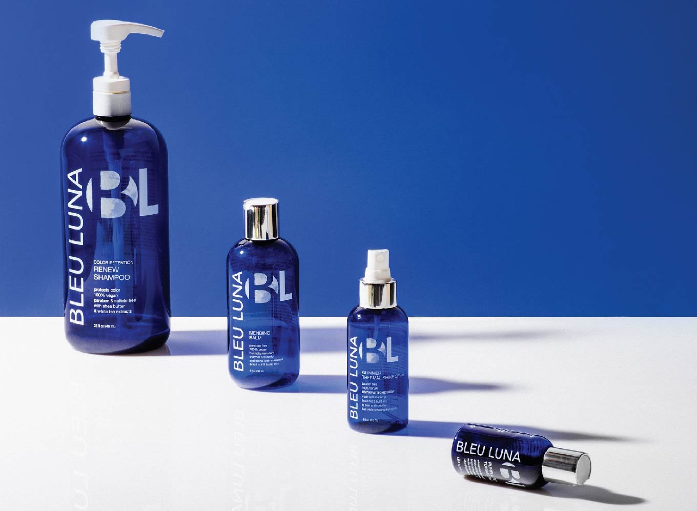 4 blue shampoo bottles with the Bleu Luna logo and labels on them.